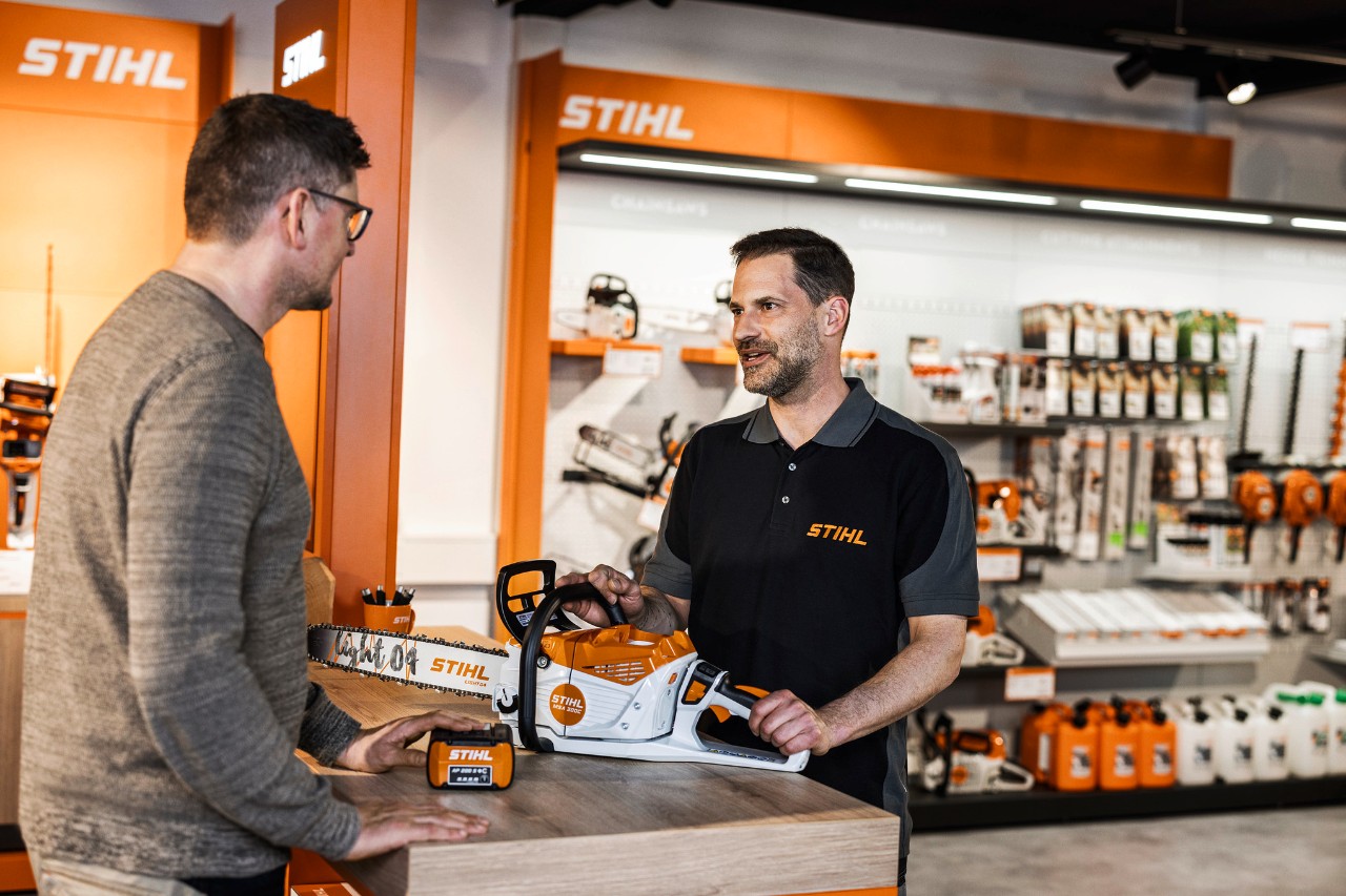 Dealer STIHL doradza klientom w zakresie akumulatorowej pilarki łańcuchowej STIHL MSA 300 w swoim salonie sprzedaży