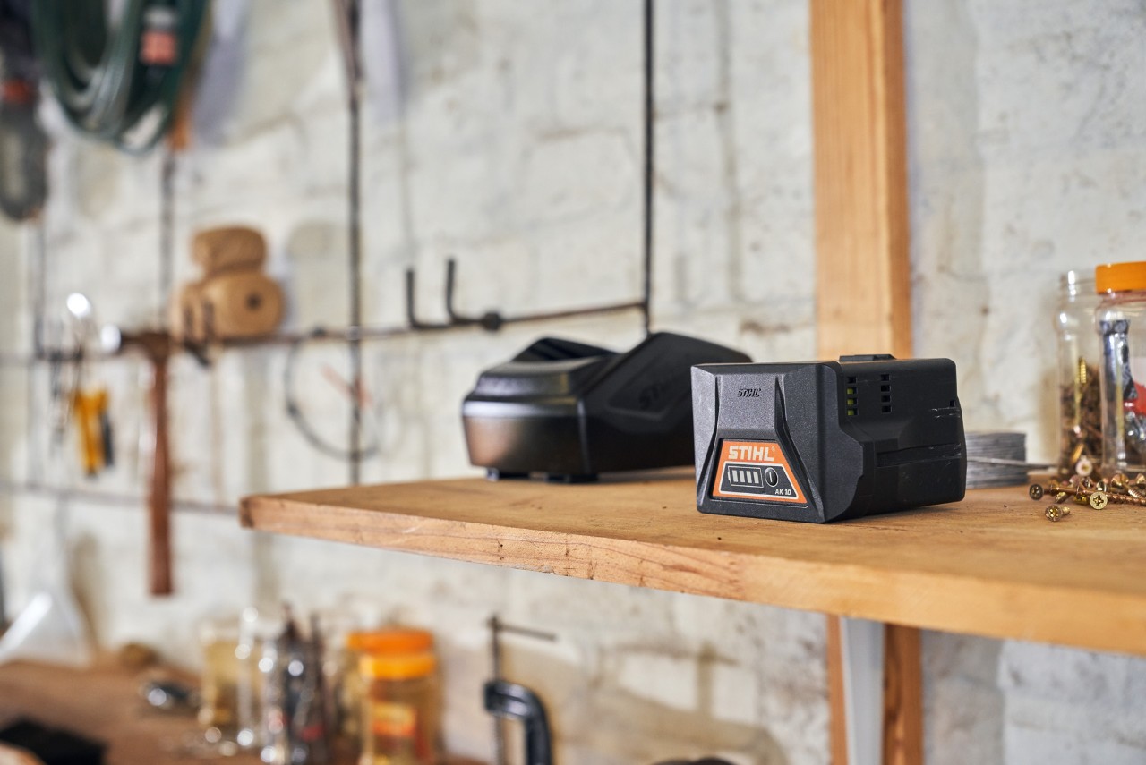 Dwa akumulatory z technologią akumulatorową STIHL leżą na półce w warsztacie