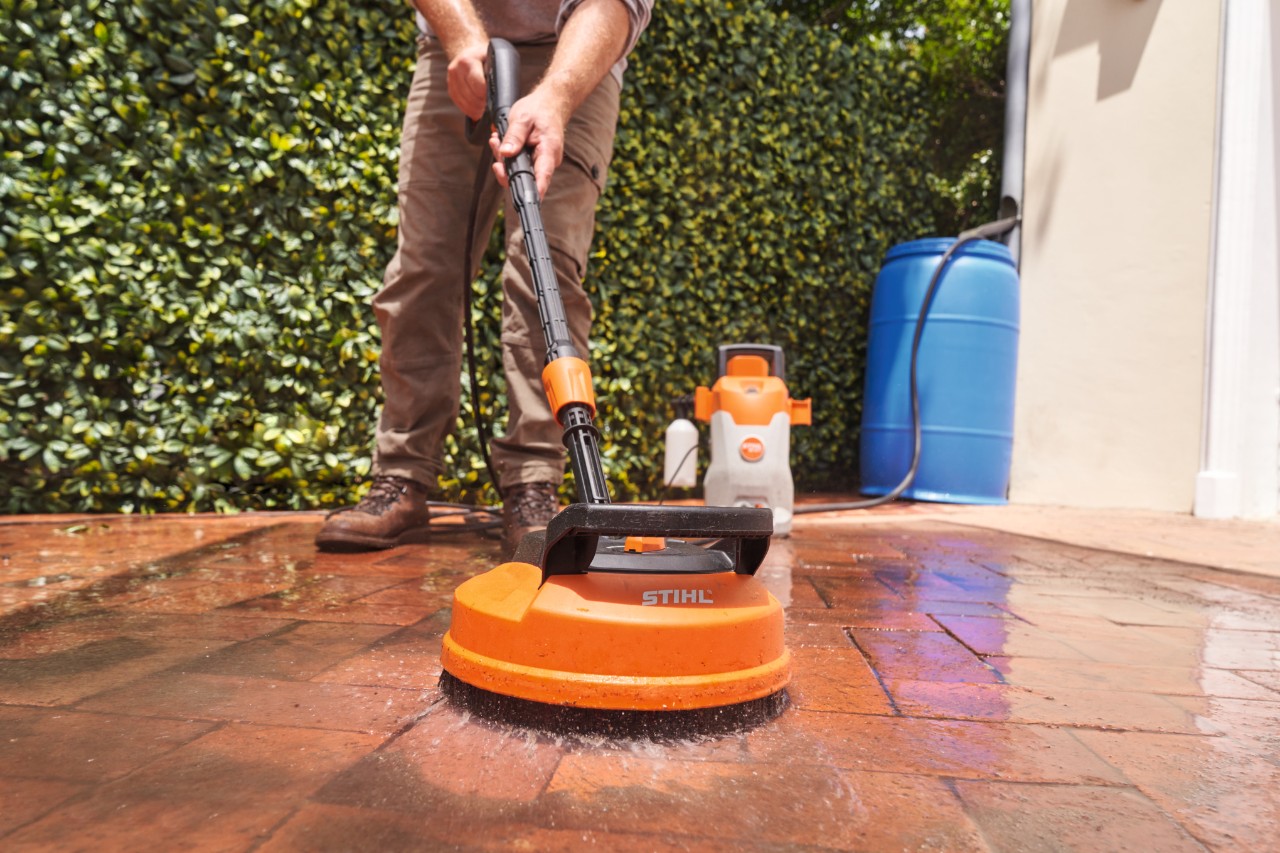 Zbliżenie na elektryczną myjkę wysokociśnieniową STIHL RE 80 X do czyszczenia kostki brukowej na tarasie