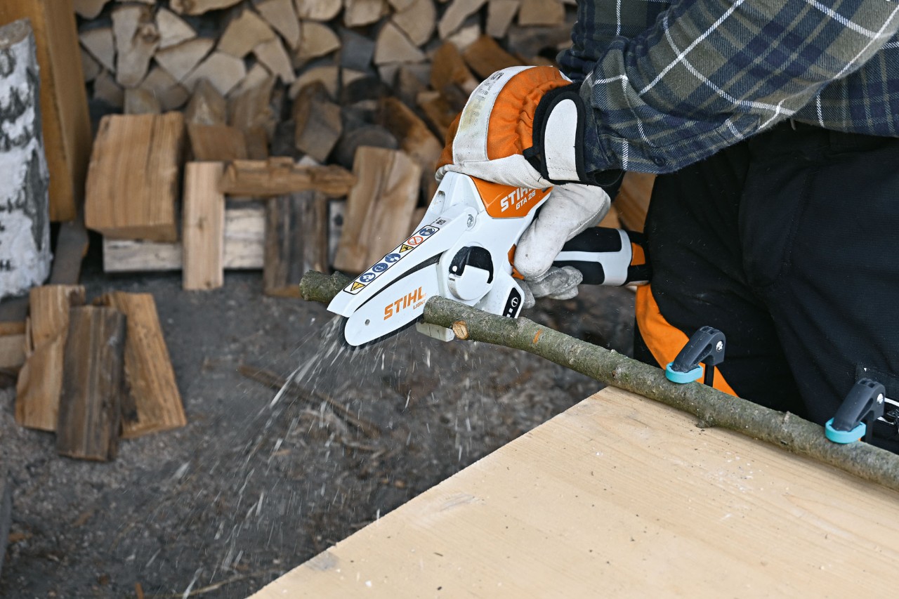 Zbliżenie na osobę obcinającą gałąź akumulatorową przecinarką STIHL GTA 26