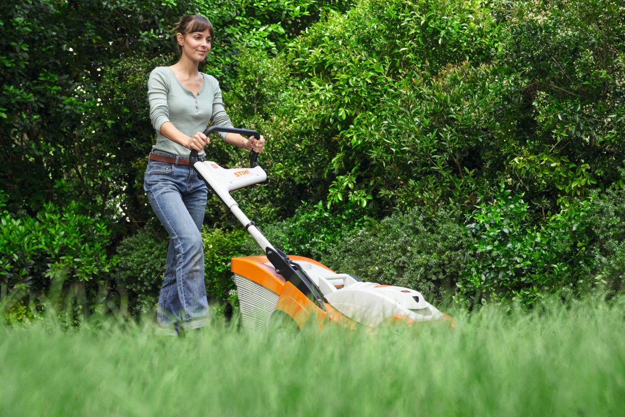 Kobieta kosi trawnik kosiarką STIHL