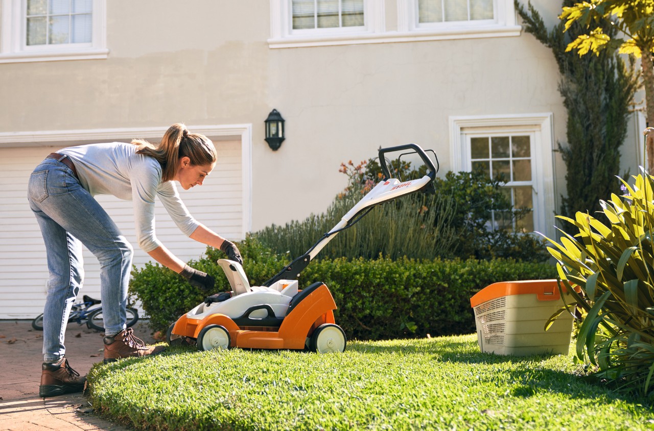 Pokrywa kosiarki akumulatorowej STIHL RMA 339 C przed białym domem