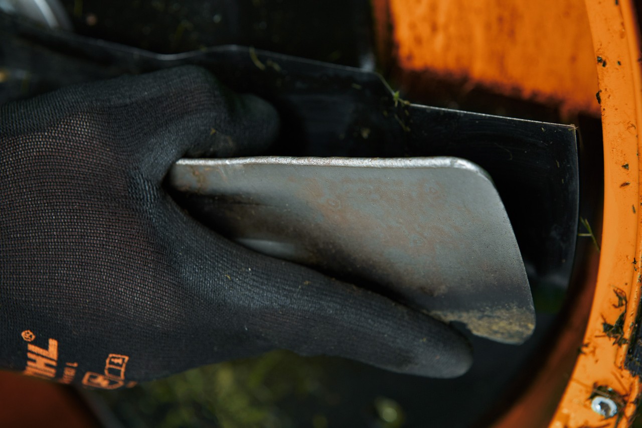 Noże znajdujące się na spodzie kosiarki STIHL należy wyczyścić szpatułką, a następnie naostrzyć.
