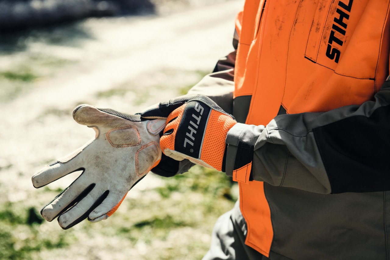 Osoba zakładająca rękawice ochronne STIHL