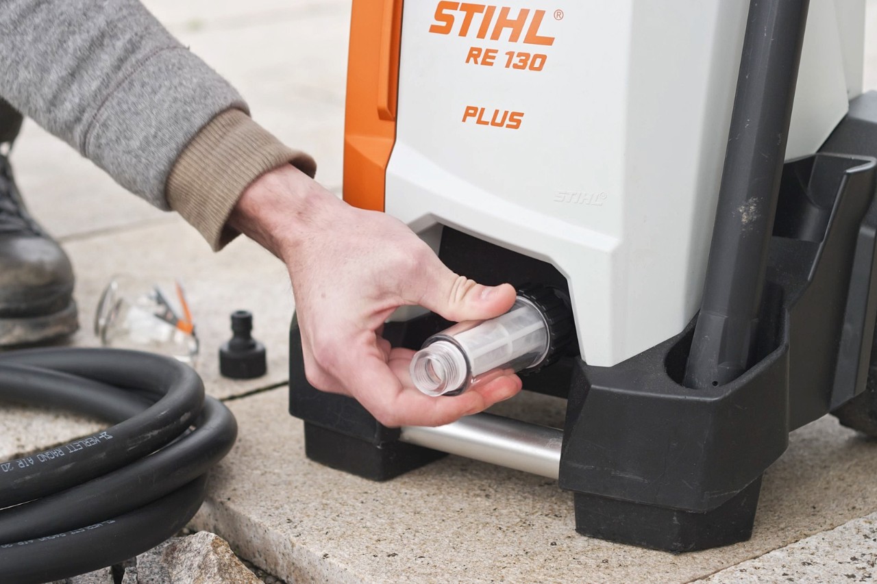 Osoba sprawdzająca podłączenie myjki wysokociśnieniowej STIHL RE 130 PLUS