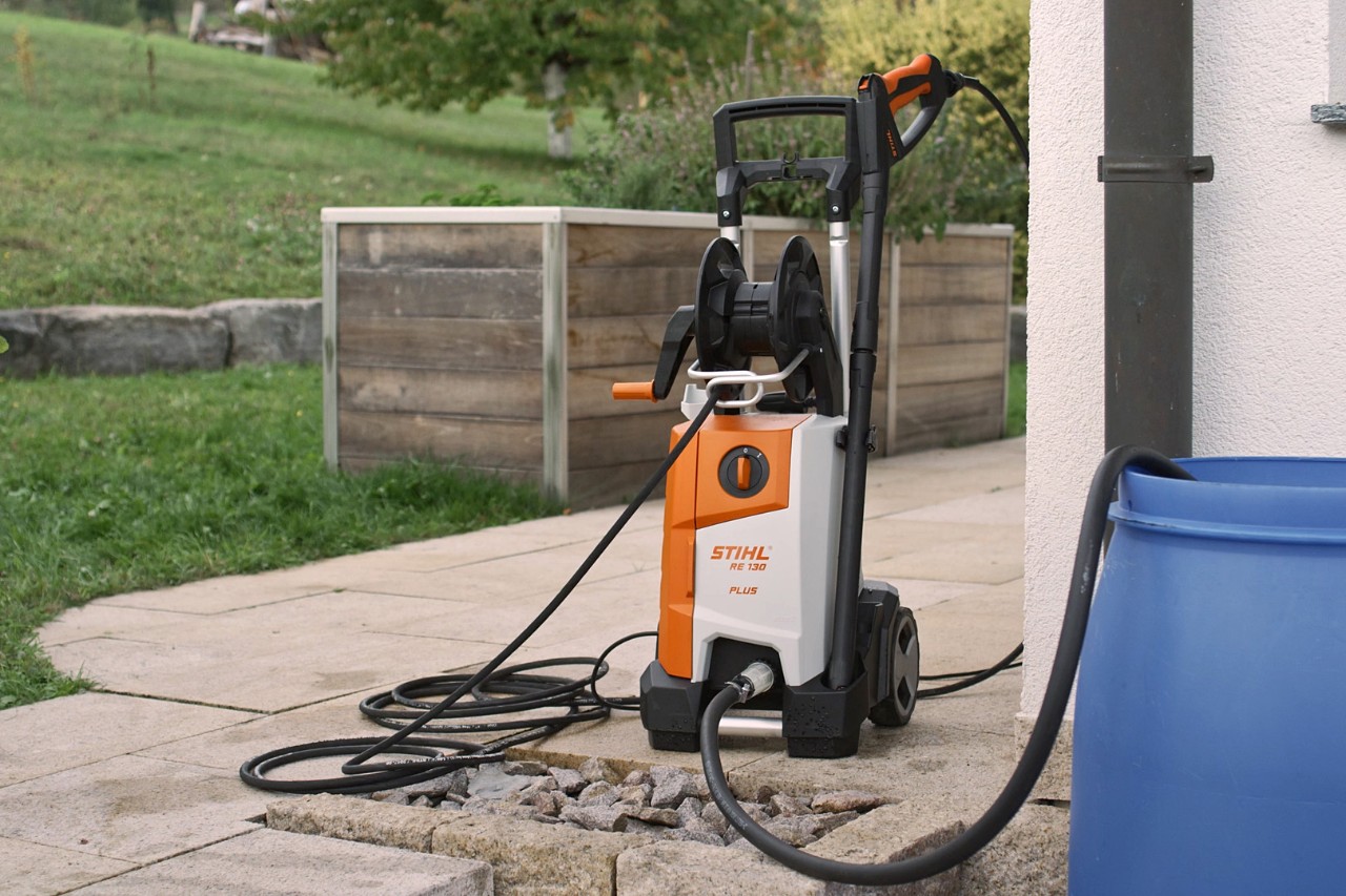 Podłączona myjka wysokociśnieniowa STIHL RE 130 PLUS na tarasie, gotowa do użycia 