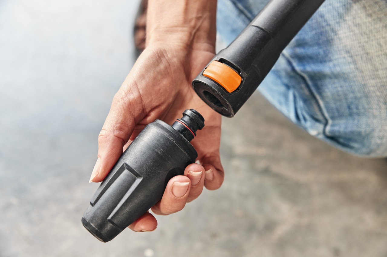  Osoba montująca nasadkę do myjki wysokociśnieniowej STIHL RE 130 PLUS w celu jej użycia