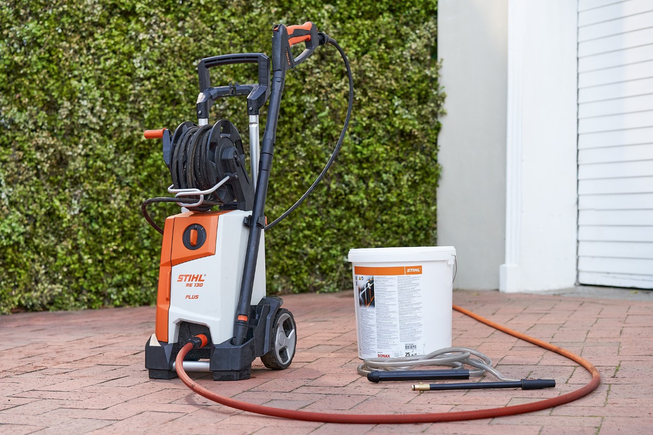 Myjka wysokociśnieniowa STIHL RE 130 PLUS i granulat ścierny SB 90 do czyszczenia na mokro przed garażem 