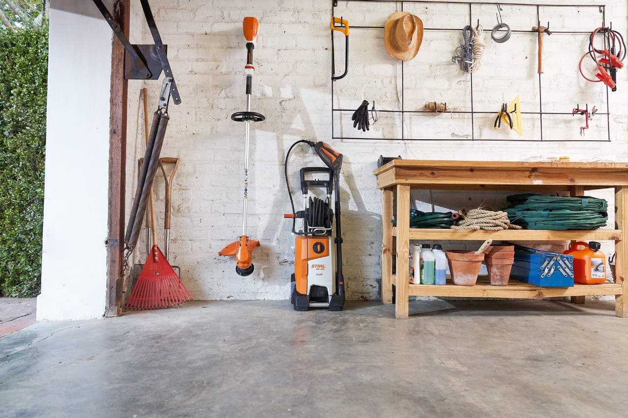Myjka wysokociśnieniowa STIHL RE 130 PLUS w garażu z innymi narzędziami