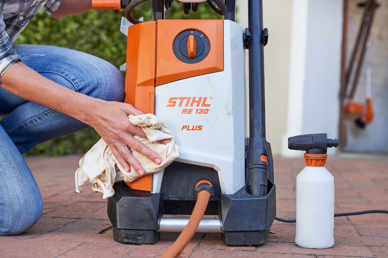 Kobieta czyszcząca myjkę wysokociśnieniową STIHL RE 130 PLUS środkiem przeciw zamarzaniu w celu konserwacji myjki wysokociśnieniowej