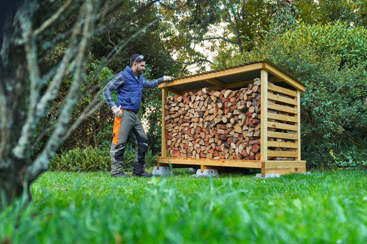 Tylko z licencją na obsługę pilarki: Osoba używająca pilarki benzynowej STIHL MS 261 C-M z prowadnicą Light 04 tnie pień drzewa w lesie