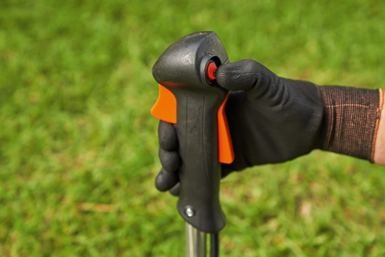 Mężczyzna wyłącza benzynową kosę mechaniczną STIHL FS 56