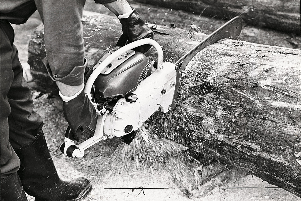 Stare czarno-białe zdjęcie pokazujące cięcie drzewa pilarką STIHL Contra 