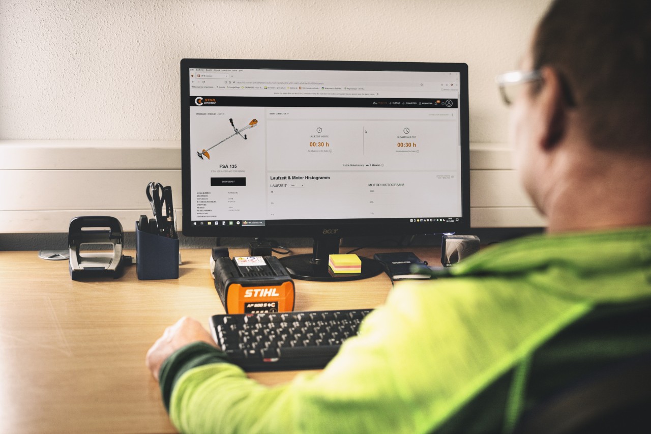 Ein Mitarbeiter der Farwick GmbH in Rückenansicht befindet sich vor einem bottTainer powered by STIHL