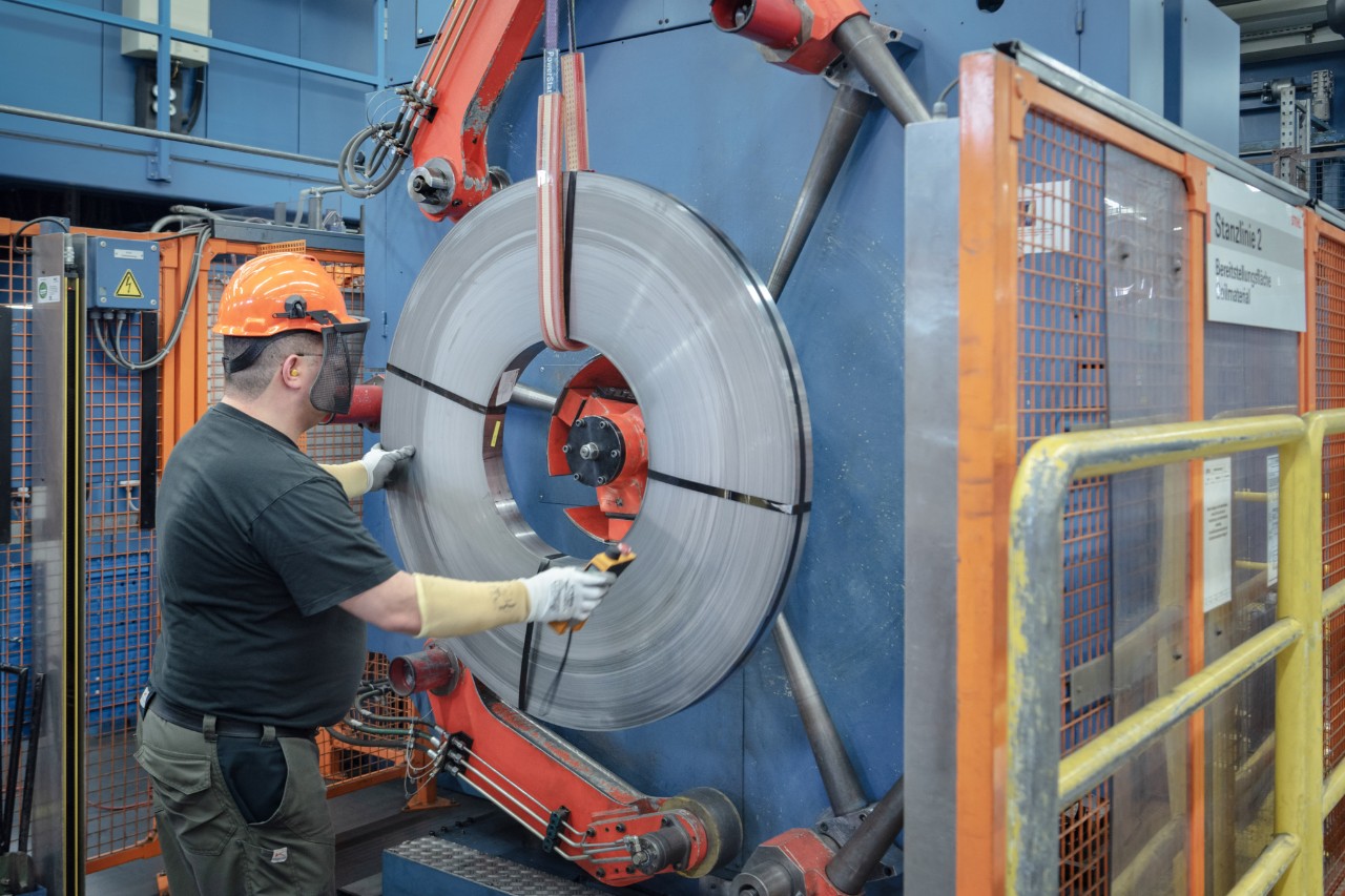 Mężczyzna w odzieży ochronnej pracuje przy maszynie do produkcji prowadnic w STIHL 